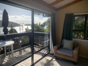 a room with a balcony with a view of the water at The Retreat in Paihia