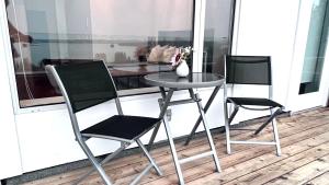 a table and two chairs on a balcony with a table at Oceanview Property in West Vancouver