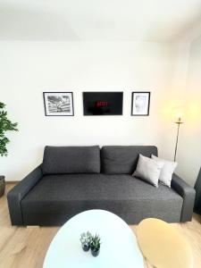 a living room with a couch and a clock on the wall at Isabellas: Near to trainstation in Linz