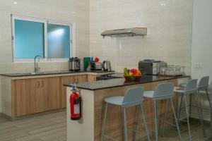 a kitchen with a counter and stools and a fire extinguisher at Lakaz Kreol in Beau Vallon