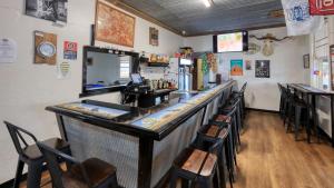 un bar dans un restaurant avec un comptoir et des chaises dans l'établissement White Cliffs Hotel, à White Cliffs