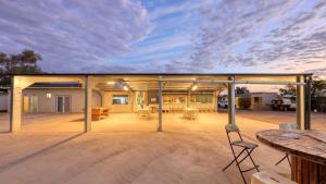 un grand patio avec une table et des chaises dessus dans l'établissement White Cliffs Hotel, à White Cliffs