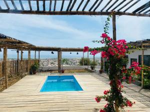 曼科拉的住宿－El Mirador de Máncora，一座房子,在甲板上设有游泳池和鲜花