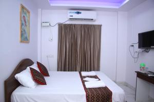 Una habitación de hotel con una cama con toallas. en ELL Parasio, en Port Blair