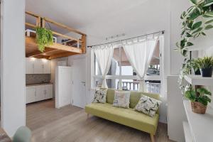 a living room with a green couch and a kitchen at Torviscas Endless Summer in Adeje