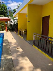 a yellow house with a swimming pool next to it at Villas de piscina in Sipalay