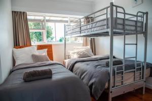 Marinoにある'Oasis in Marino' w/ Ocean Views, Sunroom + Studyのベッド2台と二段ベッドのある寝室