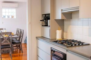 Marinoにある'Oasis in Marino' w/ Ocean Views, Sunroom + Studyのコンロ付きのキッチン テーブルの横にあるトップオーブン