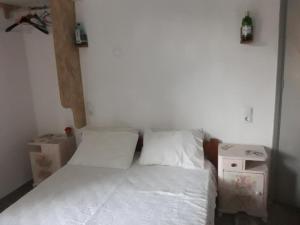 a small bedroom with a bed with white sheets at ΤΟΥΡΙΣΤΙΚΕΣ ΕΠΙΠΛΩΜΕΝΕΣ ΚΑΤΟΙΚΙΕΣ φροσω χωριατη in Agios Kirykos