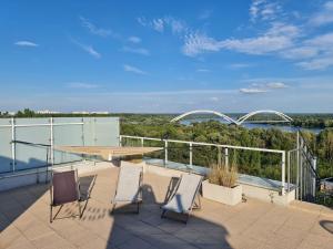 a patio with chairs and a table on a balcony at Perfect Stay - "Best View Penthouse" - free parking in Toruń