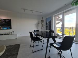 a dining room with a table and chairs and a statue at Perfect Stay - "Best View Penthouse" - free parking in Toruń +13 photos