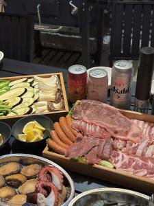 a table topped with different types of meats and vegetables at ポセイドン グランピング Poseidon Glamping in Kujukuri