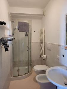 y baño con 2 aseos, ducha y lavamanos. en Stella Marina a 100 MT dal mare, en Livorno