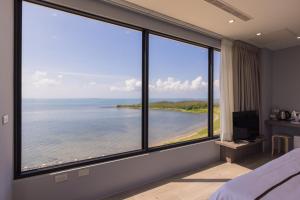 a bedroom with large windows with a view of the ocean at Penghu Swing Sea Homestay in Magong