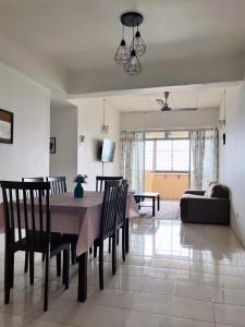 a dining room and living room with a table and chairs at Homestay Vista3A at Vista Seri Putra in Kajang