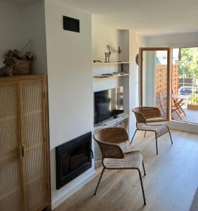 a living room with three chairs and a fireplace at PIRINEOS 3 in Panticosa