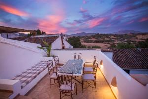 a patio with a table and chairs on a balcony at AIRE RURAL JIMENA in Jimena de la Frontera