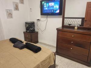 una camera con letto, cassettiera e TV di בית אירוח בנהריה a Nahariyya