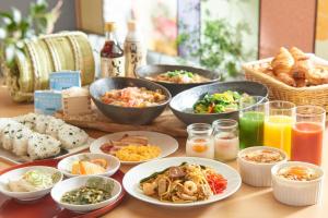 una mesa con muchos platos de comida y bebida en Kanazawa Tokyu Hotel, en Kanazawa