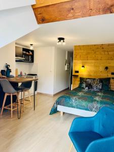 Schlafzimmer mit einem Kopfteil aus Holz, einem Bett und einem Schreibtisch in der Unterkunft Le Bellevue in Barcelonnette