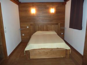 uma pequena cama num quarto com paredes de madeira em bambous-bungalows em Entre-Deux