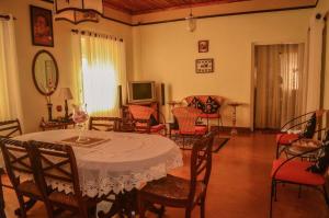 a living room with a table and chairs and a television at Crystal Holiday Bungalow in Bandarawela +22 photos