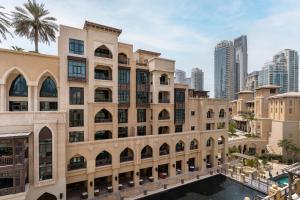 a building with a pool in front of a city at Classic & New - 1BR Apartment in OldTown,Downtown - Allsopp&Allsopp in Dubai