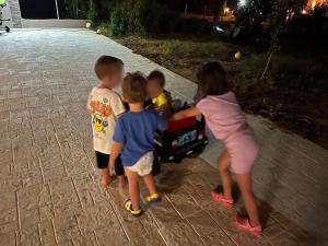 un gruppo di bambini che si aggirano intorno a un'auto giocattolo di Stbs Luxury, Nea Fokea a Nea Fokea