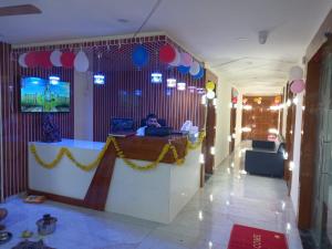a man sitting at a desk with a laptop in a room at HOTEL RK VILLA in Vadodara