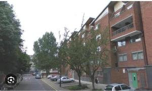 a city street with cars parked in front of a building at Nino Homes Kings cross in London