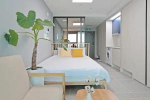 a bedroom with a large bed and a potted plant at Elmomento Gwangan in Busan