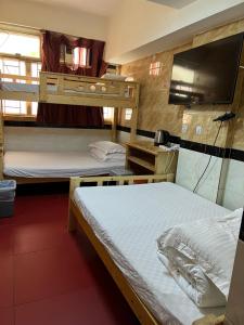 a room with two bunk beds and a flat screen tv at 泰豪賓館 in Hong Kong