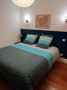 a bedroom with a bed with a blue headboard at La croisée des hautes côtes in Détain-et-Bruant