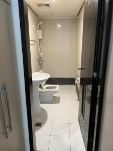 een badkamer met een toilet en een wastafel bij eton emerald loft ortigas in Manilla