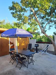 une table et des chaises avec un parasol sur une terrasse dans l'établissement TI CASE TRANQU'ILE OTE !, à Saint-Pierre