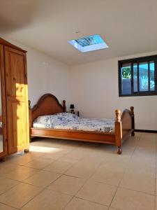 une chambre avec un lit et une lucarne dans l'établissement TI CASE TRANQU'ILE OTE !, à Saint-Pierre