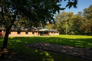 ein Gebäude mit einem Rasenplatz mit einem Baum in der Unterkunft Jägerhuset in Maribo