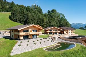 eine Luftansicht eines Hauses mit einem Teich in der Unterkunft Alpenchalets Oberlaiming in Itter