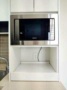 a microwave oven sitting on a shelf in a kitchen at Apartment near Ilsan Dongkuk University Hospital in Goyang