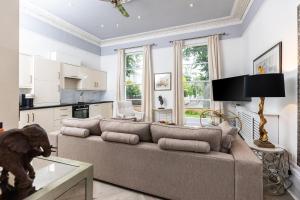 Una sala de estar con un sofá y una cocina. en 10 Sydenham - By Luxury Apartments, en Cheltenham