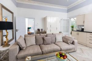 uma sala de estar com um sofá e uma cozinha em 10 Sydenham - By Luxury Apartments em Cheltenham