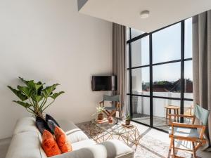 ein Wohnzimmer mit Couch und großem Fenster in der Unterkunft Tropicana Loft Canggu in Canggu + 30 Fotos