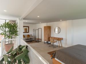 een slaapkamer met een bed en een bureau op een balkon bij Tropicana Loft Canggu in Canggu +30 foto's