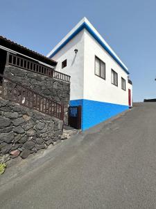un edificio blanco y azul con una pared de piedra en Casa Jesus en Fuencaliente de la Palma