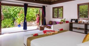 a woman standing in a bedroom with a large bed at Navutu Stars Resort in Matayalevu