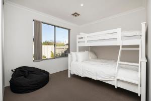 1 dormitorio con literas blancas y ventana en Jakes Place, en Dunsborough