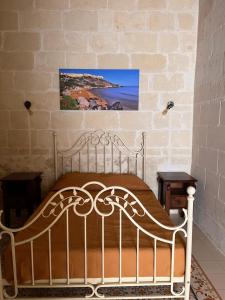 un letto bianco in una stanza con un muro di mattoni di House with pool & jacuzzi for 5 persons a Nadur