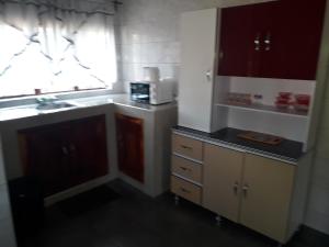 uma pequena cozinha com um lavatório e um micro-ondas em A Nice Homely 2- Bedroom House em Livingstone