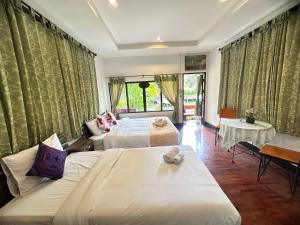 Ban Yang PlaoにあるSoft Resort Kad Farang Hangdongのベッド2台とソファが備わるホテルルームです。