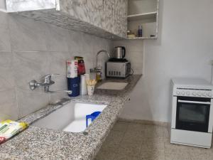 una piccola cucina con lavandino e piano cottura di בית אירוח בנהריה a Nahariyya